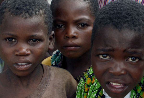 Africké děti v Malawi přihlížejí davu, který provází popstar Madonnu.